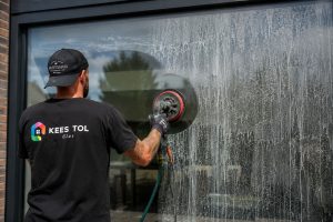 Glaszetters van Kees Tol Glas verwijderen aanslag machinaal.